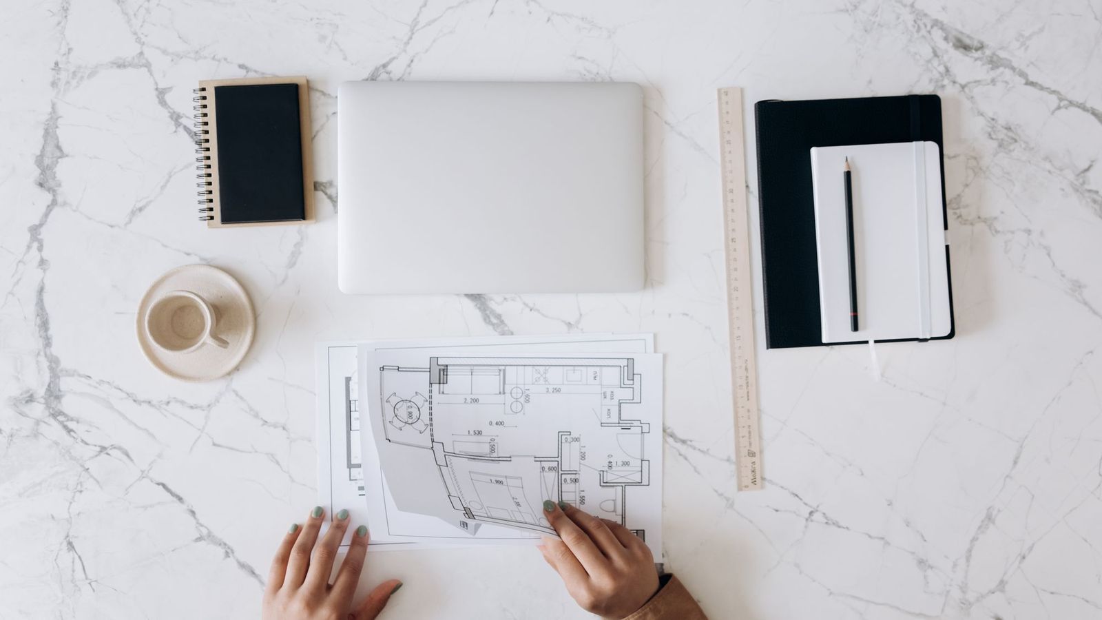 Table de travail couverte de plans, phase d'études et de conception en maîtrise d'œuvre