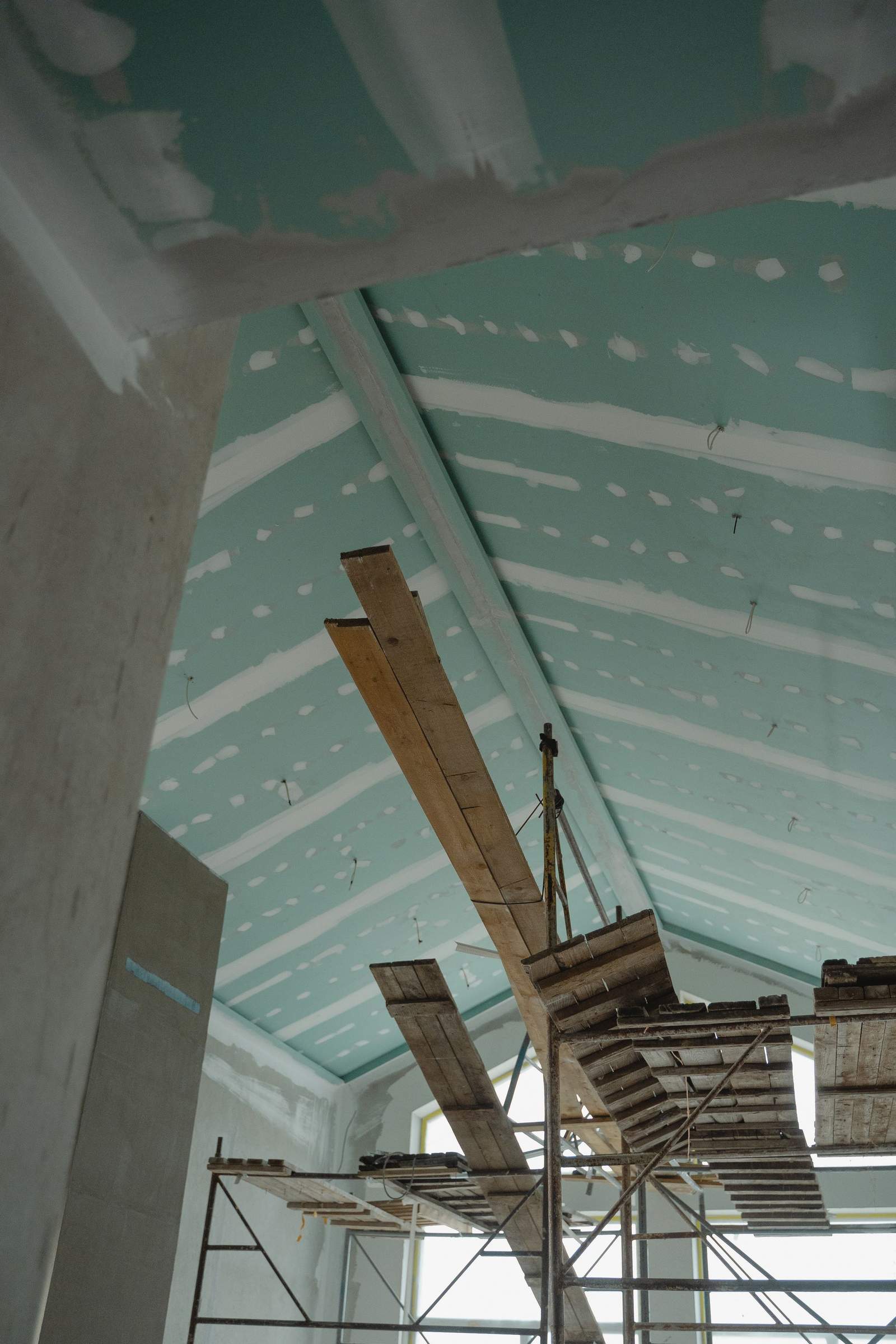 Pose d'un faux plafond technique en second œuvre sur un chantier d'aménagement intérieur
